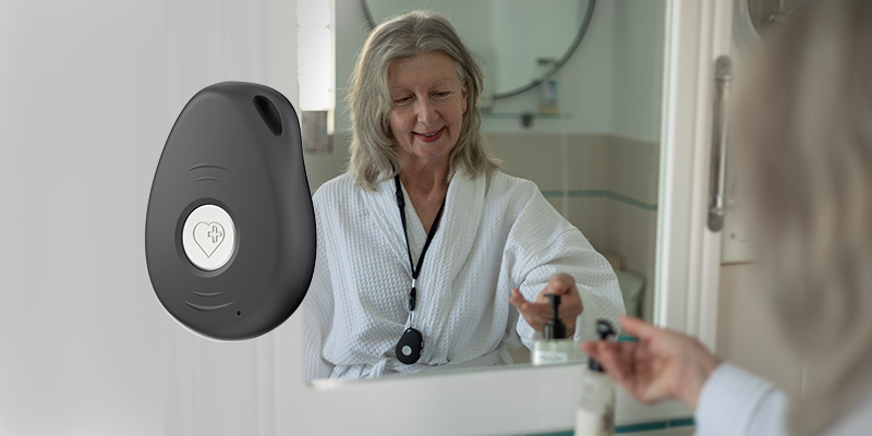 Senior woman with personal emergency alarm pendant at home