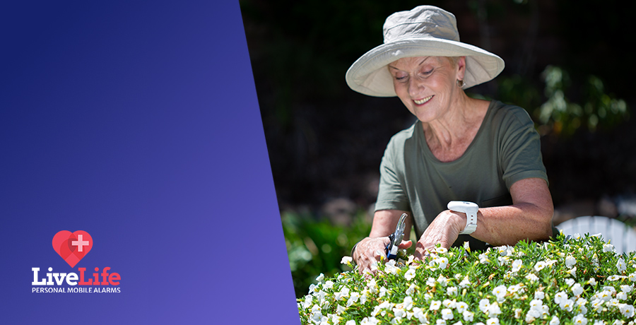 Senior lady gardening, wearing a livelife pendant.